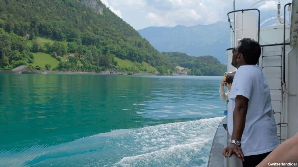 tourist at the railing of a ship enjoying the beautiful view of Lake Thun