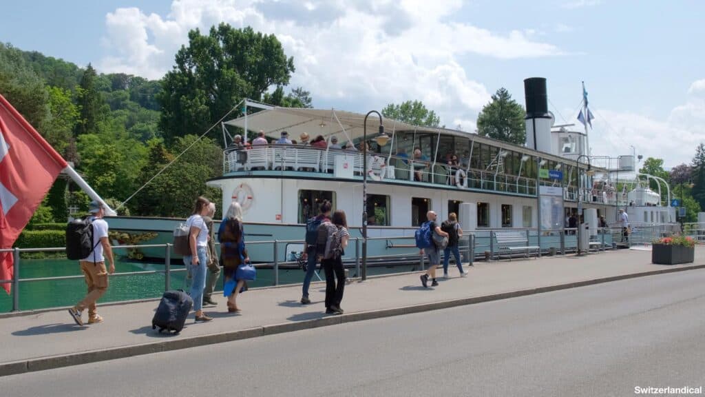 Tourists are walking towards the Blüemlisalp ship at Thun train station.
